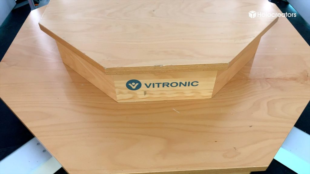 Auf dem Sockel des Vitronic Vitus Körper-3D-Scanners ist das Vitronic-Logo zu sehen.